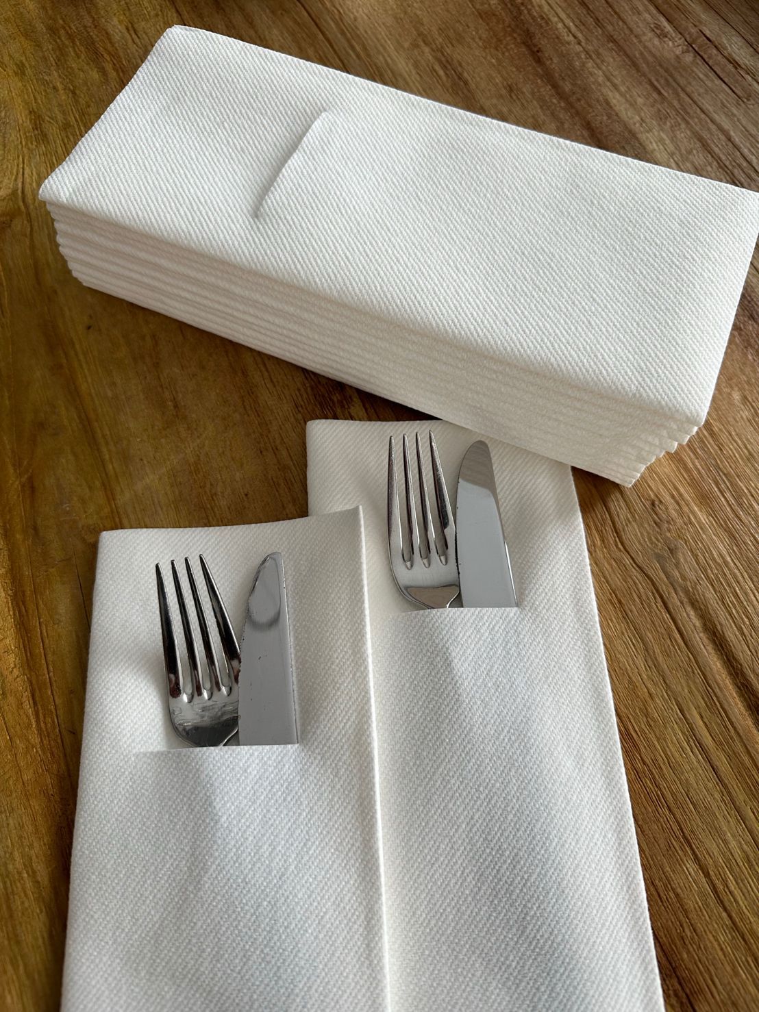 Premium pocketservet met subtiele logodruk op een gedekte tafel